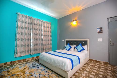 a bedroom with a large bed with blue walls at The Bunksters Bir in Bīr