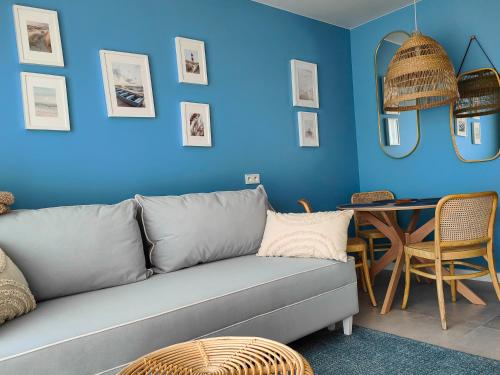 a blue living room with a couch and a table at Aurora Spa Nadmorskie Zacisze Dziwnów in Dziwnów
