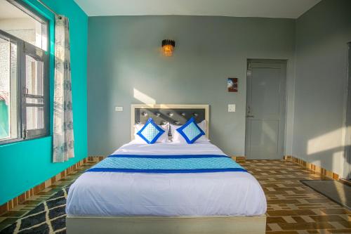 a large bed in a room with blue walls at The Bunksters Bir in Bīr