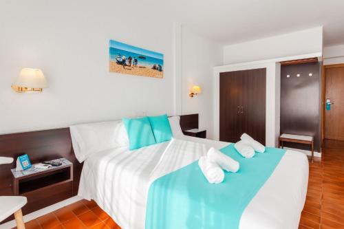 a hotel room with a bed with towels on it at Checkin Torredembarra in Torredembarra