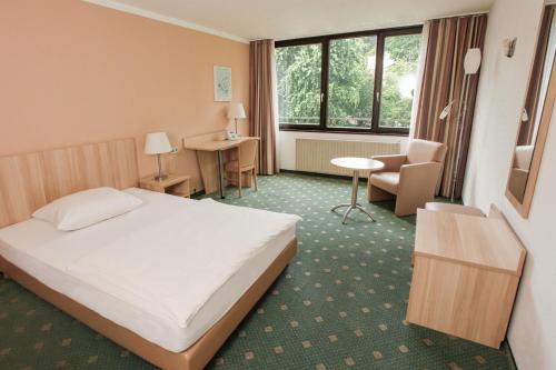 a hotel room with a bed and a chair at Appartis - Boardinghouse am Klostersee in Sindelfingen