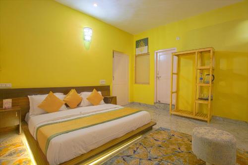 a bedroom with a large bed in a yellow room at The Bunksters Bir in Bīr