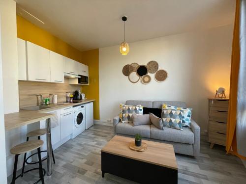 une cuisine et un salon avec un canapé et une table dans l'établissement Studio proche de la gare, à Auxerre