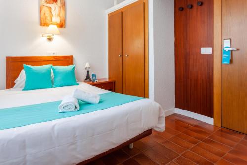a bedroom with a bed with two towels on it at Checkin Torredembarra in Torredembarra