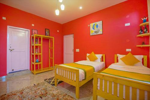 two beds in a room with red walls at The Bunksters Bir in Bīr
