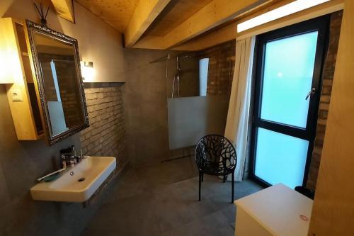 a bathroom with a sink and a chair and a window at Ferien - Wohnung möbliert ehemalige Scheune in Heppenheim an der Bergstrasse