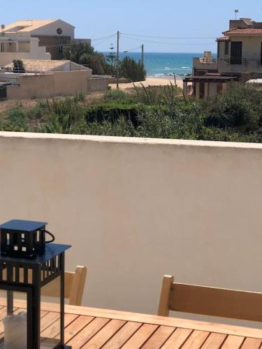a table sitting on a deck with a view of the ocean at Micencisettanta in Donnalucata