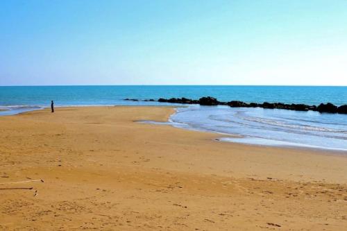 a person standing on a beach near the ocean at Micencisettanta in Donnalucata
