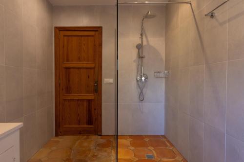 a shower with a wooden door in a bathroom at Buccara Casa Gran Daniel I in Pollença