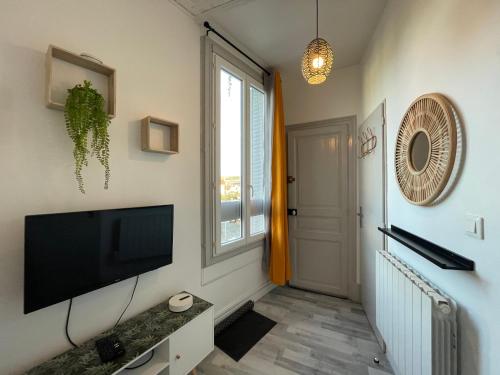 un salon avec une télévision à écran plat et une fenêtre dans l'établissement Studio proche de la gare, à Auxerre