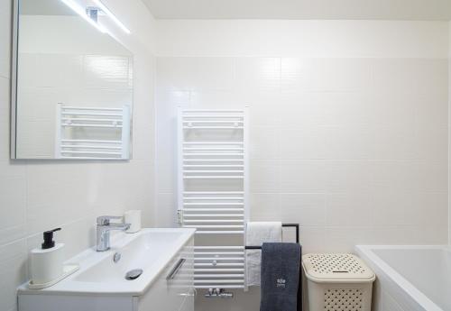 ein weißes Bad mit einem Waschbecken und einem WC in der Unterkunft Apartmány Myslivna in Ostrov
