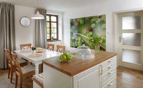 a kitchen with a table with a bowl of apples on it at Apartmány Myslivna in Ostrov