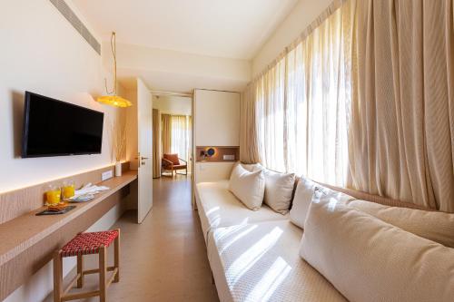 Habitación de hotel con sofá blanco y ventana grande. en Eurotel Altura, en Altura