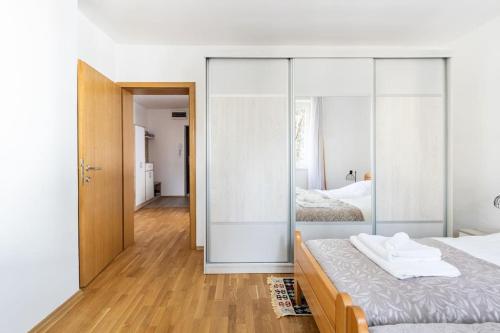 1 dormitorio con 2 camas y pared de cristal en Apartman DINO en Sarajevo