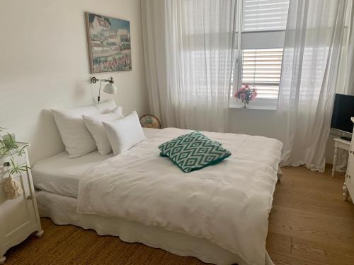 ein Schlafzimmer mit einem weißen Bett und einem Kissen darauf in der Unterkunft AVLiving City ROOM Basel in Basel