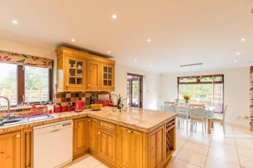 Una cocina con gabinetes de madera y un comedor. en Host & Stay - Four Seasons, en Norwich