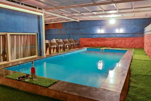 - une piscine dans une pièce entourée de chaises dans l'établissement Ekant Villa Panchgani Mahabaleshwar, à Panchgani