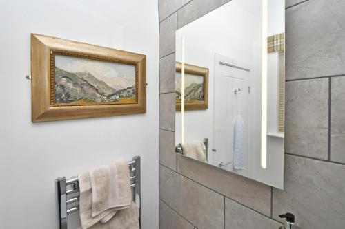 a bathroom with a mirror and a painting on the wall at The Masons Arms in Newcastle under Lyme