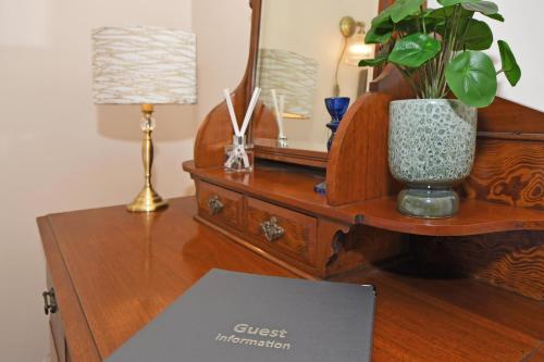 a desk with a dresser with a potted plant on it at The Masons Arms in Newcastle under Lyme