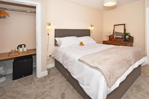 um quarto com uma cama grande, uma secretária e um espelho. em The Masons Arms em Newcastle under Lyme