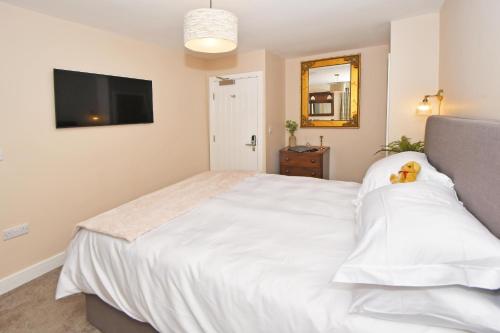 a bedroom with a large white bed with a teddy bear on it at The Masons Arms in Newcastle under Lyme