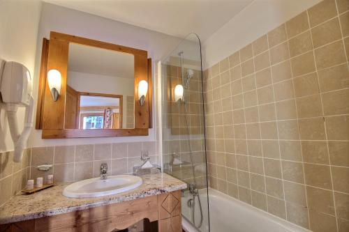 a bathroom with a sink and a mirror and a tub at ARC 1950 - Appartement 10 personnes Duplex Cheminée - ski aux pieds - Sauna, Hammam, Jacuzzi in Arc 1950