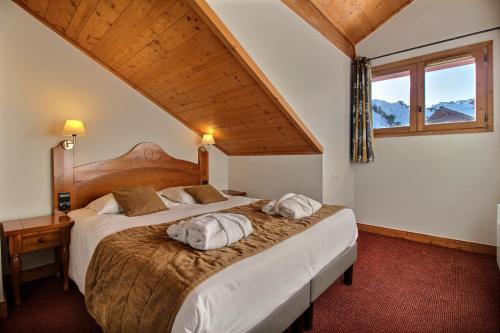 une chambre avec deux lits avec des oreillers dessus dans l'établissement ARC 1950 - Appartement 10 personnes Duplex Cheminée - ski aux pieds - Sauna, Hammam, Jacuzzi, à Arc 1950