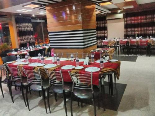 a dining room with tables and chairs with red and white plates at Castle Bay Touch Cox's Bazar in Cox's Bazar