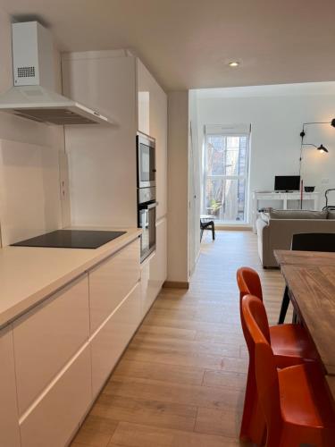 une cuisine avec des armoires blanches et un plancher en bois dans l'établissement Duplex 107 - Agen hyper centre - Mairie, à Agen