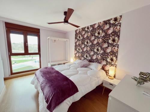 a bedroom with a bed with a floral accent wall at Almamater salamanca in Salamanca