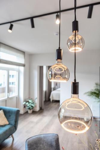 a living room with several lights hanging from the ceiling at Hof van In & Wellness in Hasselt