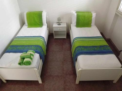 レウカにあるVilletta ristola s m di leucaの緑の枕が備わる小さな部屋のベッド2台