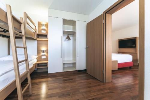 a bedroom with two bunk beds and a tv at Swiss Holiday Park Resort in Morschach