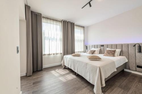 a bedroom with a large bed with white sheets at Hof van In & Wellness in Hasselt