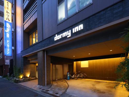 a building with a sign on the side of it at Dormy Inn Tokyo Hatchobori Hot Spring in Tokyo