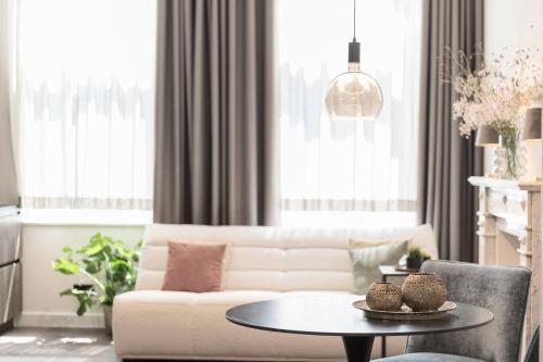 a living room with a white couch and a table at Hof van In & Wellness in Hasselt