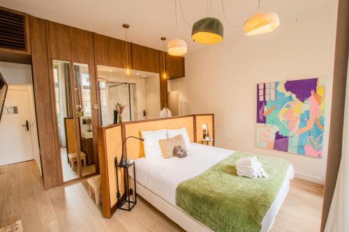 um quarto com uma cama grande e um cobertor verde em LOLA Boutique Hôtel - Bordeaux Centre em Bordeaux