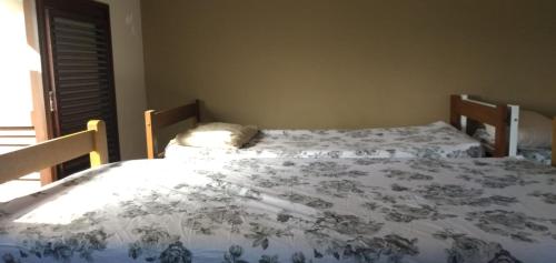 two twin beds in a room with a window at Conceitual Hostel Natal in Natal