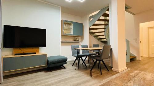 a living room with a dining room table with a flat screen tv at Kleine Burg Ovelgönne in Ovelgönne