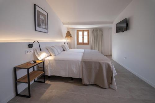 a bedroom with a bed and a table with a lamp at Tres Tocs in Ciutadella