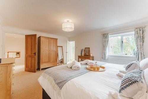 a bedroom with a large white bed with a tray on it at Astley House - Norfolk Cottage Agency in Blakeney