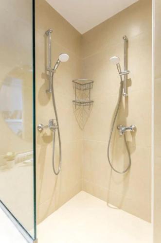 une salle de bain avec une douche avec une porte vitrée dans l'établissement Picasso, rue Debelleyme 4 places, à Paris