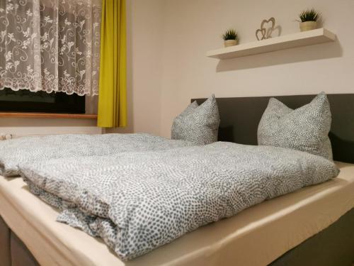 a bedroom with a bed with a black and white comforter at Ferienwohnung am Nationalpark Hunsrück Hochwald in Brücken