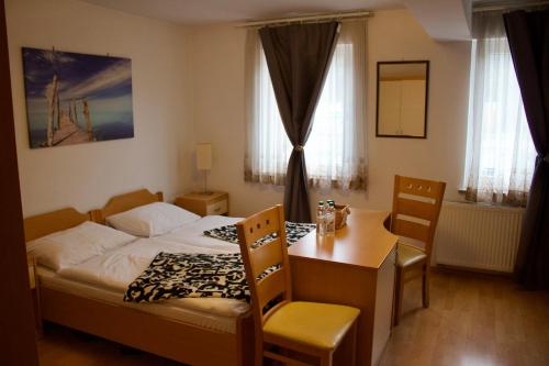 a bedroom with a bed and a table and chairs at PONI NAKLO - Sobe Marinšek in Naklo