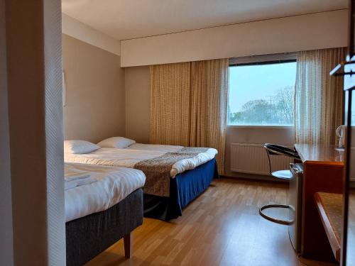 a hotel room with two beds and a window at Hotel Sommelo in Kouvola