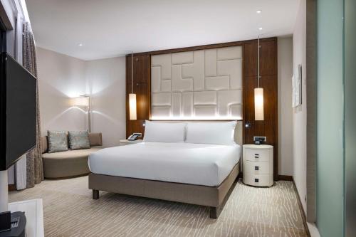 a bedroom with a large white bed and a couch at Hilton Batumi in Batumi