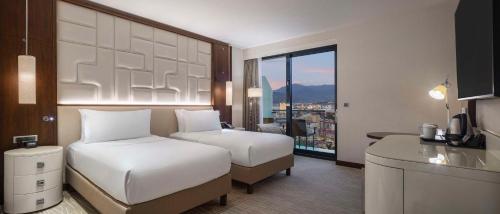 a hotel room with two beds and a view of a city at Hilton Batumi in Batumi