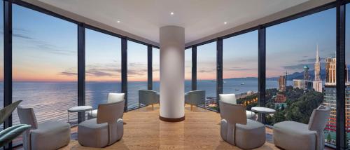 a room with a view of the ocean from a building at Hilton Batumi in Batumi