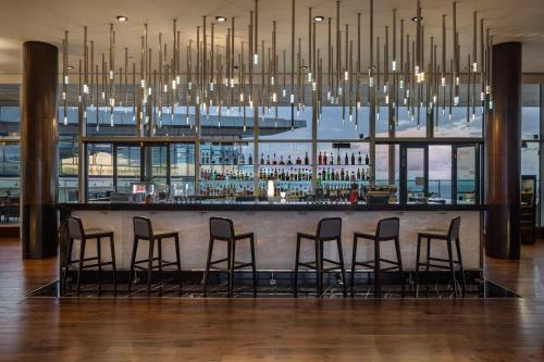 a bar with chairs and a large chandelier at Hilton Batumi in Batumi