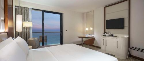 a hotel room with a bed and a view of the ocean at Hilton Batumi in Batumi